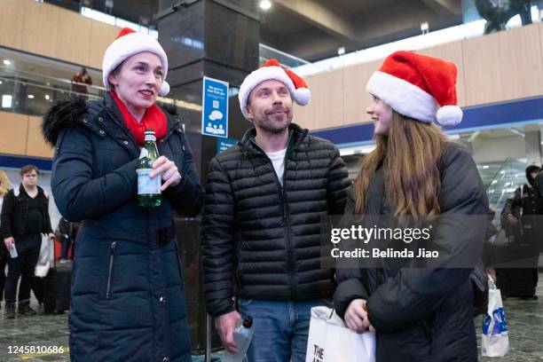 Family of three wearing Santa hats at London Euston train station on December 24, 2022 in London, England. Rail strikes over the Christmas period...