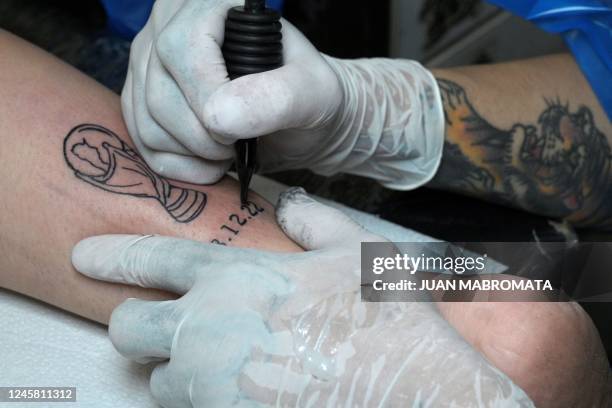 Alma Ocampo receives a tattoo of the FIFA World Cup trophy and the date when Argentina won the third world cup at Ds Tattoo Shop in Buenos Aires on...