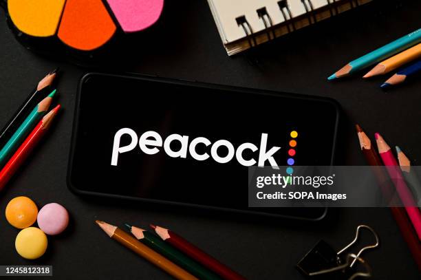 In this photo illustration a Peacock logo seen displayed on a smartphone.