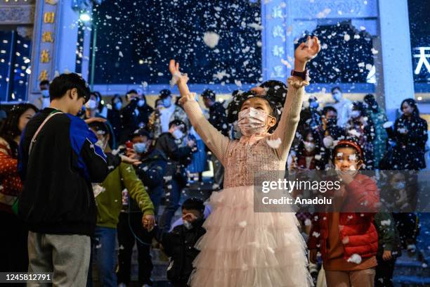 Children are seen having fun with the snow machine as the new year approaches in Guangzhou, China on December 24, 2022.