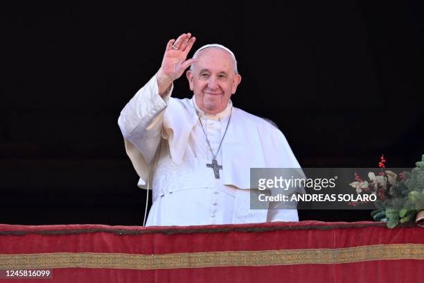 Pope Francis waves to the crowd as he appears at the balcony to deliver his Christmas Urbi et Orbi blessing in St. Peter's Square at The Vatican on...