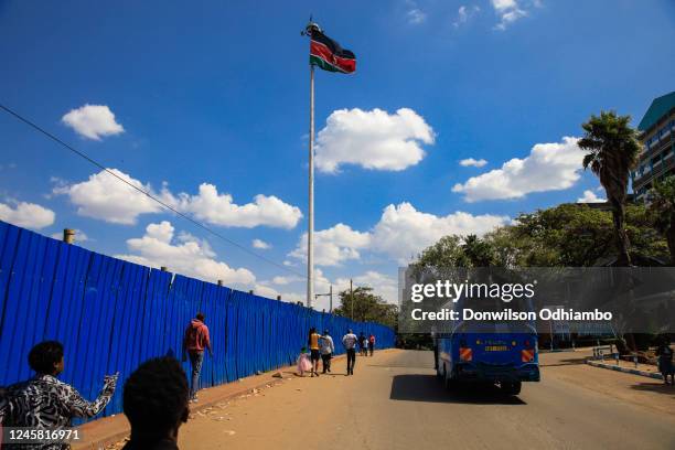 Residents walk past a Kenyan flag headed to Uhuru Park for Christmas celebrations on December 25, 2022 in Nairobi, Kenya. National police services in...