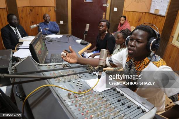 Radio station employees are pictured during a Christmas day live show in Wad al-Bashir village, 20 km west of Omdurman, the twin city of Sudan's...