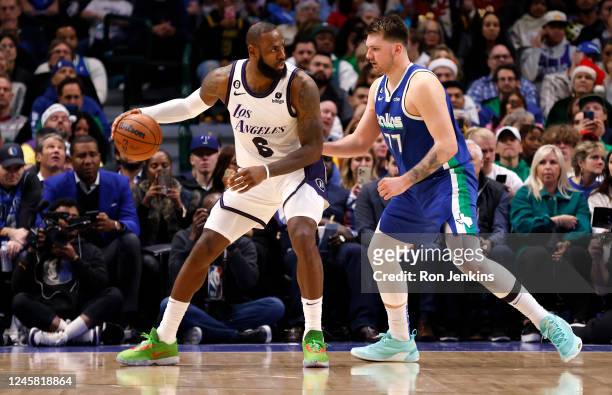LeBron James of the Los Angeles Lakers handles the ball as Luka Doncic of the Dallas Mavericks defends in the second half at American Airlines Center...