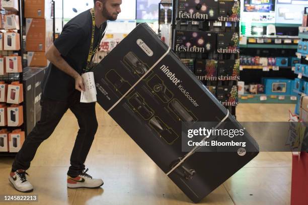 An employee moves a Ninebot Ltd., Kick Scooter at a JB Hi-Fi Ltd. Store in Sydney, Australia, on Monday, Dec. 26, 2022. Australias consumer sentiment...