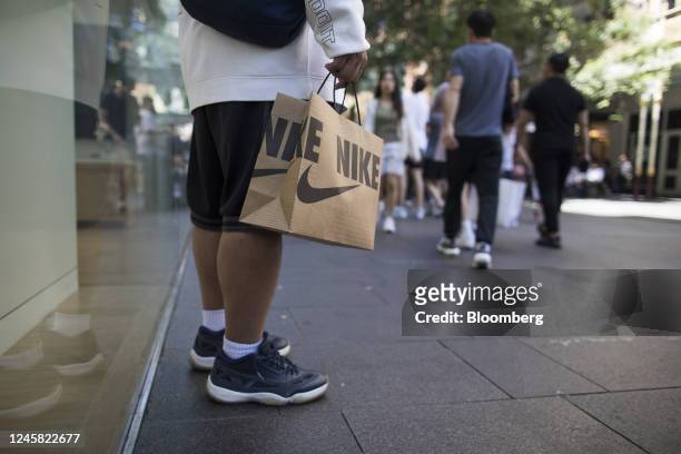 Man carries a Nike branded bag at Pitt Street Mall in Sydney, New South Wales, Australia, on Monday, Dec. 26, 2022. Australias consumer sentiment...