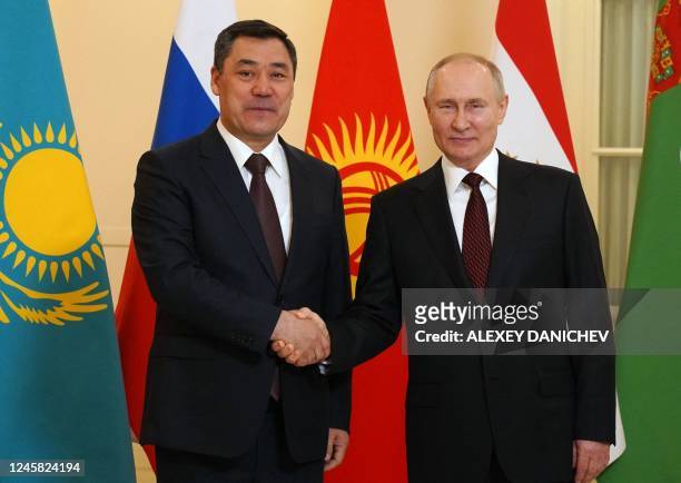 Russian President Vladimir Putin greets Kyrgyzstan's President Sadyr Japarov ahead of an informal meeting of the heads of state of the Commonwealth...
