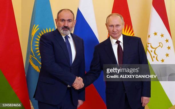 Russian President Vladimir Putin greets Armenian Prime Minister Nikol Pashinyan ahead of an informal meeting of the heads of state of the...