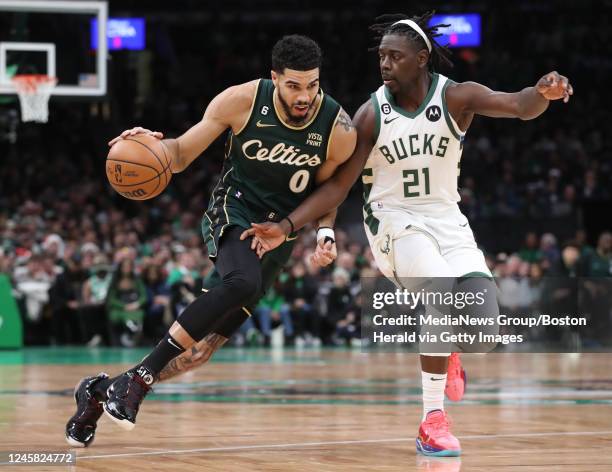 Boston Celtics forward Jayson Tatum drives past Milwaukee Bucks guard Jrue Holiday during the first quarter of the Christmas Day game at the TD...