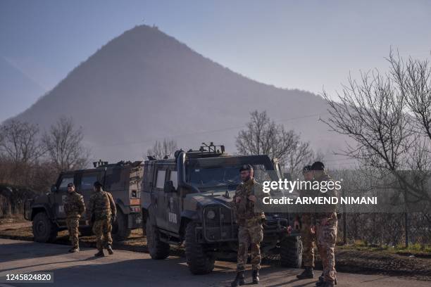 Italian soldiers serving in a NATO-led international peacekeeping mission in Kosovo patrol near a road barricaded with trucks by Serbs in the village...