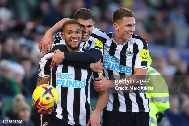 Joelinton of Newcastle United celebrates scoring the 3rd goal with Bruno Guimaraes and Sven Botman during the Premier League match between Leicester...