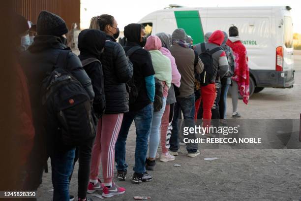 Asylum-seekers line up to be processed by US Customs and Border Patrol agents at a gap in the border fence US-Mexico near San Luis, Arizona, on...