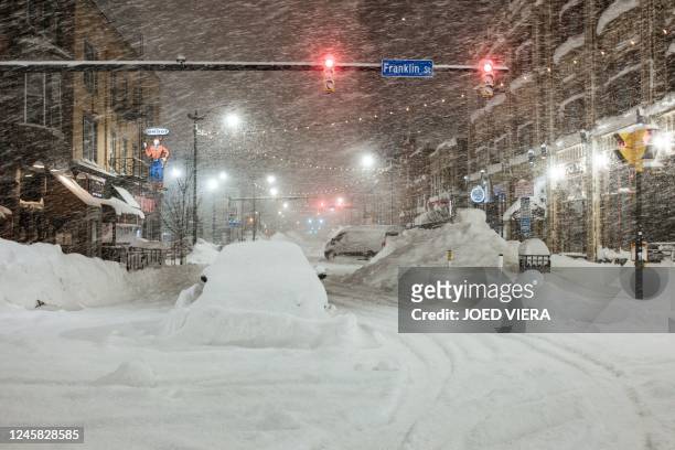 Vehicles are seen abandoned in heavy snowfall in downtown Buffalo, New York, on December 26, 2022. - US emergency crews counted the grim costs of a...
