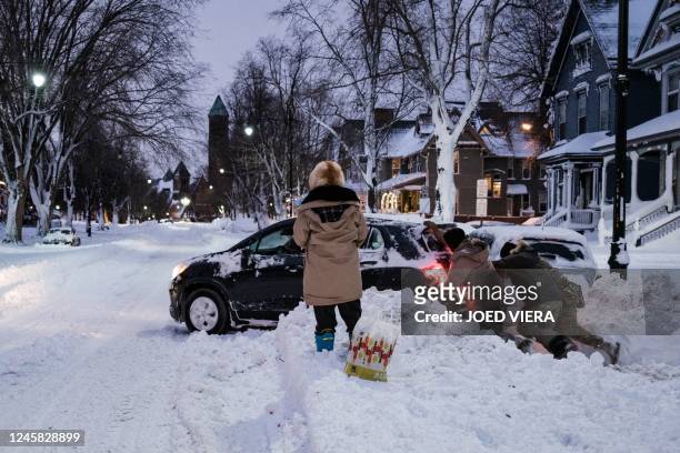 Members of the New York National Guard help to free a car stuck in the snow in Buffalo, New York, on December 25, 2022. - US emergency crews counted...