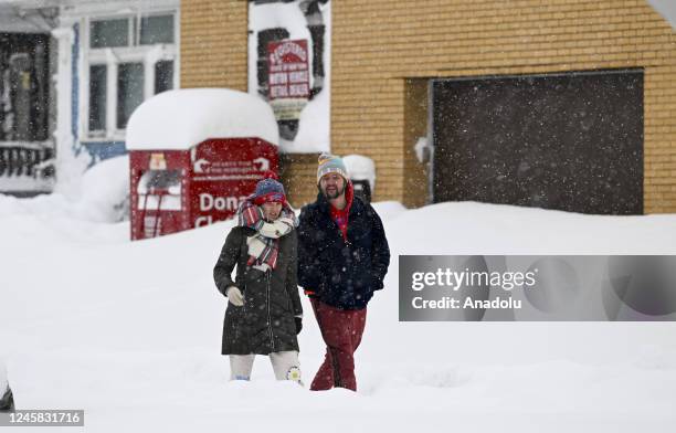 Citizens walk on the snow covered sidewalk after snowfall in Buffalo, New York, United States on December 26, 2022.