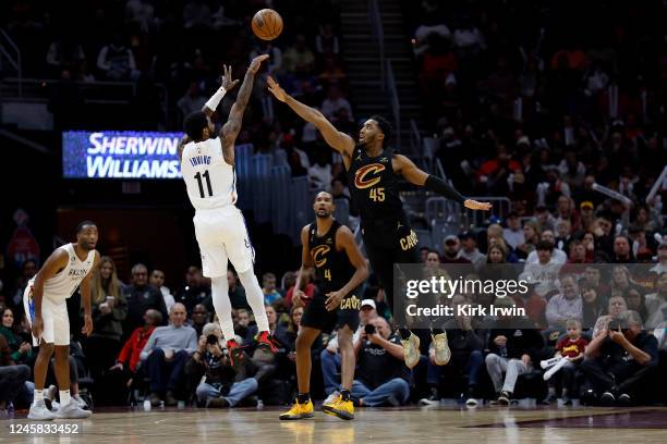 Kyrie Irving of the Brooklyn Nets shoots the ball over the defense of Donovan Mitchell of the Cleveland Cavaliers during the fourth quarter of the...