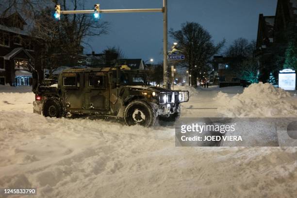 National guard truck drives along snow-covered streets in Buffalo, New York, on December 26, 2022. - Emergency crews in New York were scrambling on...