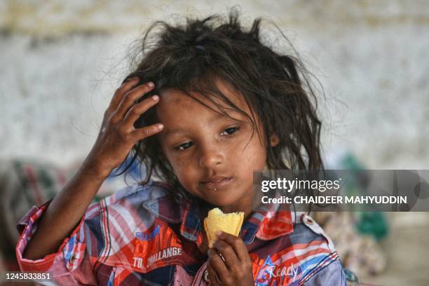 Rohingya refugee eats a biscuit at a temporary shelter following his arrival by a boat in Laweueng, Aceh province on December 27, 2022. - Rohingya...