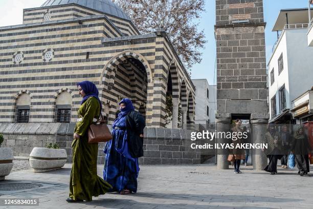 Pedestrians walk in the historical Sur district in Diyarbakir on December 23, 2022. - Bullet marks reveal the spot where a rights lawyer was shot in...