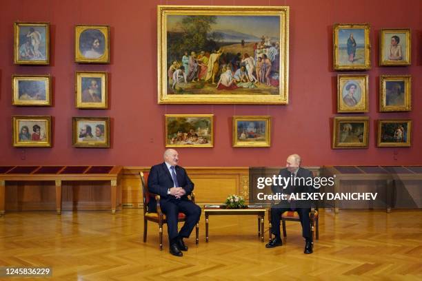 Russia's President Vladimir Putin speaks with his Belarus counterpart Alexander Lukashenko during their meeting on the sidelines of an informal...