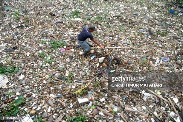 Volunteer clears garbage from the polluted Citarum river in Bandung, West Java on December 27, 2022.