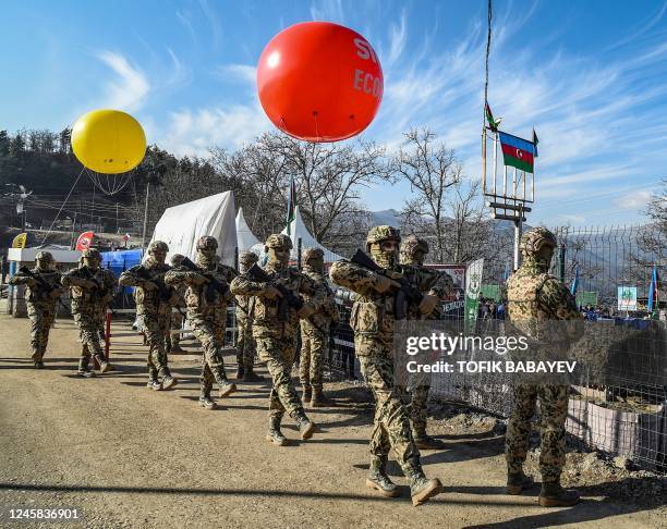 Azerbaijani servicemen stand guard at a checkpoint at the Lachin corridor, the Armenian-populated breakaway Nagorno-Karabakh region's only land link...