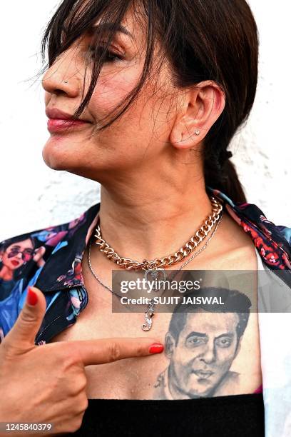 Fan shows a tattoo of Bollywood actor Salman Khan outside his residence while waiting to to wish him on his birthday, in Mumbai on December 27, 2022.