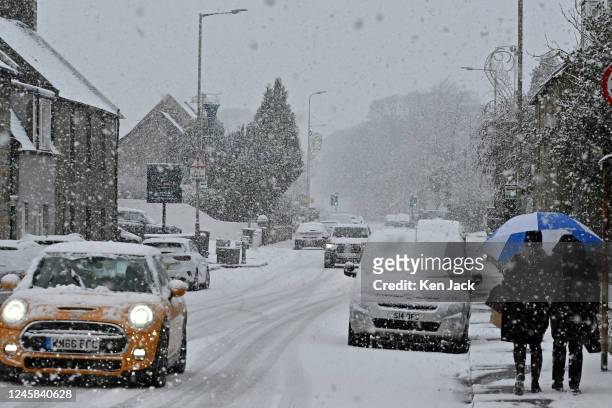 People and cars make their way through falling snow as winter weather continues to grip parts of Scotland, on December 27 2022, in Kinross, Scotland.