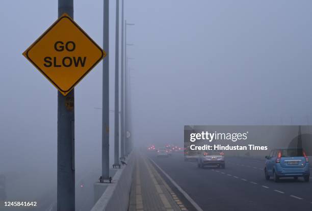 Commuters drive at slow speed amid cold and dense foggy morning at Airport Terminal on December 27, 2022 in New Delhi, India. The lowest minimum...