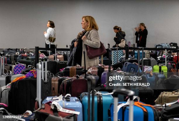 Passengers search through hundreds of unclaimed suitcases near the Southwest Airlines baggage claim area at Nashville International Airport after the...