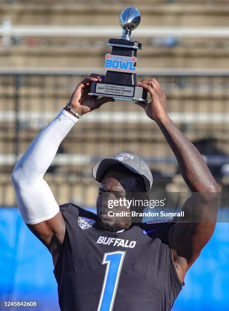 Justin Marshall of the Buffalo Bulls lifts the MVP Trophy at the conclusion of the Tax Act Camelia Bowl against the Georgia Southern Eagles at...