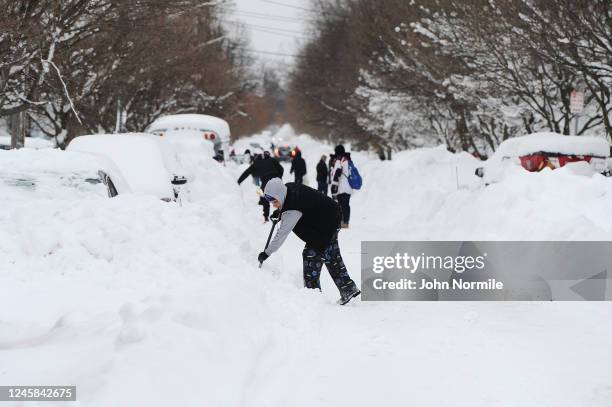 Residents on Woodside Drive clear heavy snow on December 27, 2022 in Buffalo, New York. The historic winter storm Elliott dumped up to four feet of...