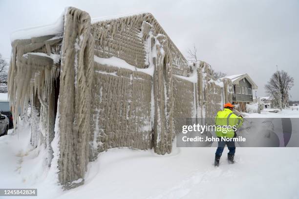 Jack Stanton checks his ice covered home after being battered with waves from Lake Erie along Hoover Beach on December 27, 2022 in Hamburg, New York....