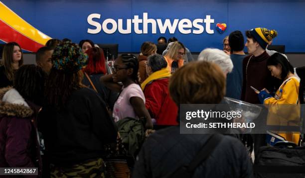 Travellers wait in line at the Southwest Airlines ticketing counter at Nashville International Airport after the airline cancelled thousands of...