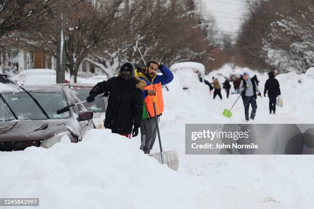 Residents on Woodside Drive clear heavy snow on December 27, 2022 in Buffalo, New York. The historic winter storm Elliott dumped up to four feet of...