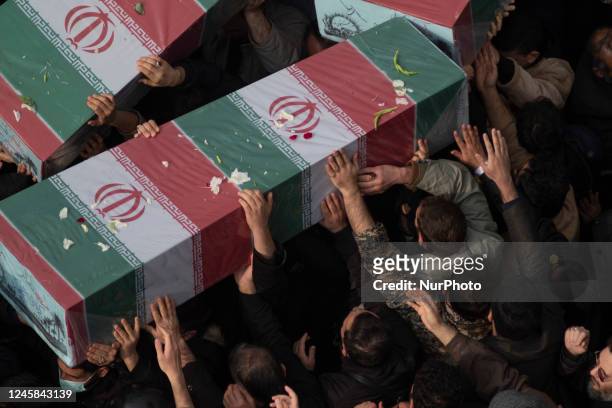 Mourners carrying coffins containing remaining of bodies of Iranian warriors who have been killed during the Iran-Iraq war, during a funeral for...