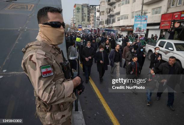 An Islamic Revolutionary Guard Corps' Samen Special Forces armed personnel monitors an area as Iranian people attend a funeral for Iran-Iraq war...