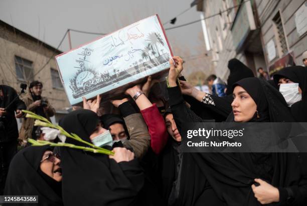 Veiled women carrying a coffin containing remaining of a body of an Iranian warrior who has been killed during the Iran-Iraq war, during a funeral...