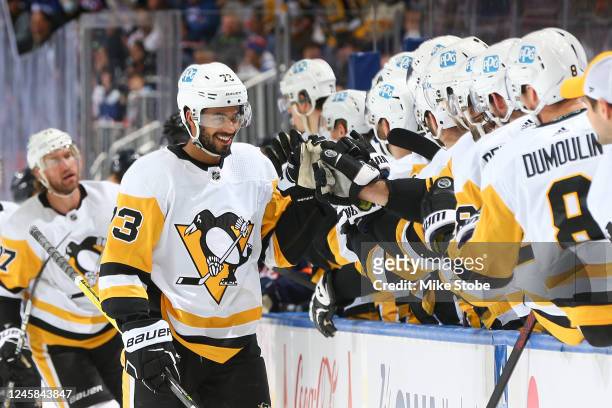 Pierre-Olivier Joseph of the Pittsburgh Penguins is congratulated by his teammates after scoring a goal against the New York Islanders during the...