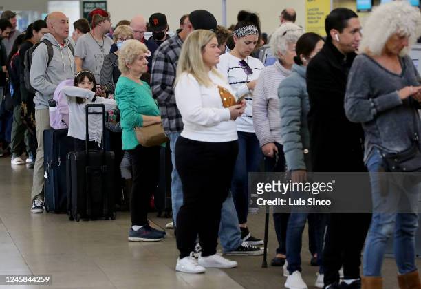 People wait in line to check in for available flights at the Southwest Airlines terminal at John Wayne Airport in Orange County on Tuesday, Dec. 27,...