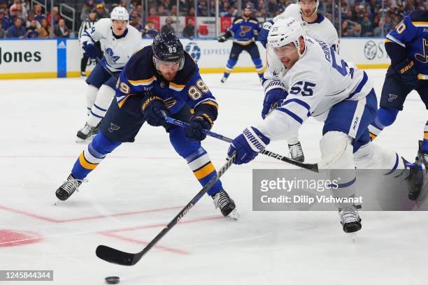 Pavel Buchnevich of the St. Louis Blues fights Mark Giordano of the Toronto Maple Leafs for control of the puck in the first period at Enterprise...