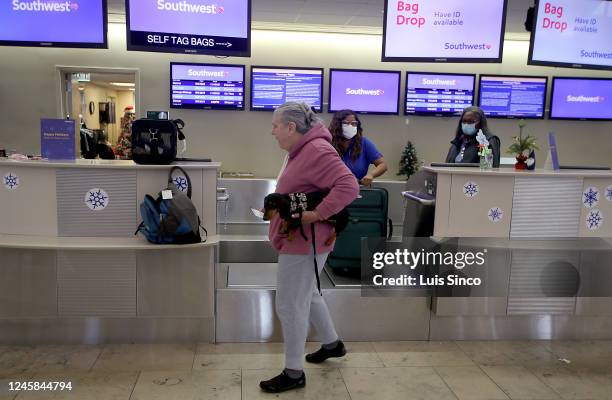 Stephanie Commerford and her dog Pickle check in for a flight at the Southwest Airlines ticket counter at John Wayne Airport in Orange County on...
