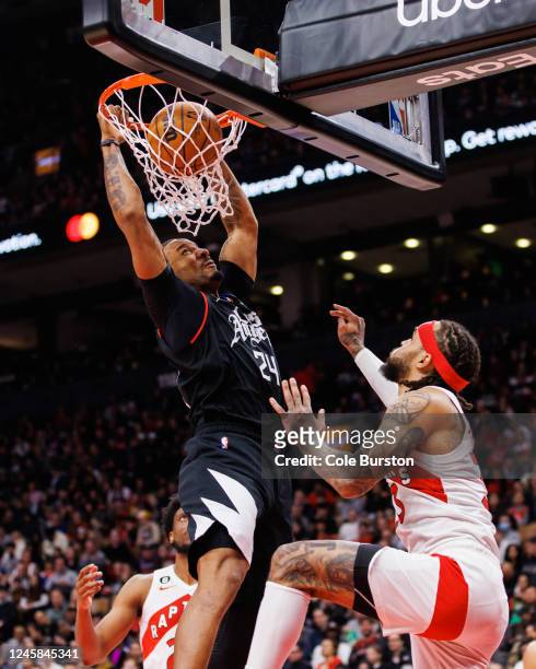 Norman Powell of the LA Clippers dunks against Gary Trent Jr. #33 of the Toronto Raptors during the second half of their NBA game at Scotiabank Arena...