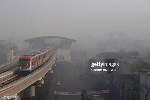 An Orange Line Metro Train is pictured on an elevated track amid heavy smog conditions in Lahore on December 28, 2022.