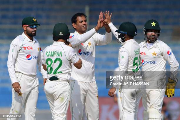Pakistan's Nauman Ali celebrates with teammates after taking the wicket of New Zealand's Henry Nicholls during the third day of the first Test match...