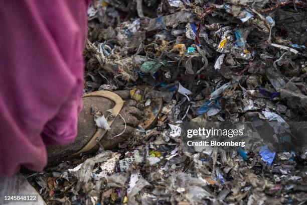 Worker sorts through a pile of waste from a paper mill at a plastic scrap yard in Muzaffarnagar District, Uttar Pradesh, India, on Thursday, Nov. 17,...