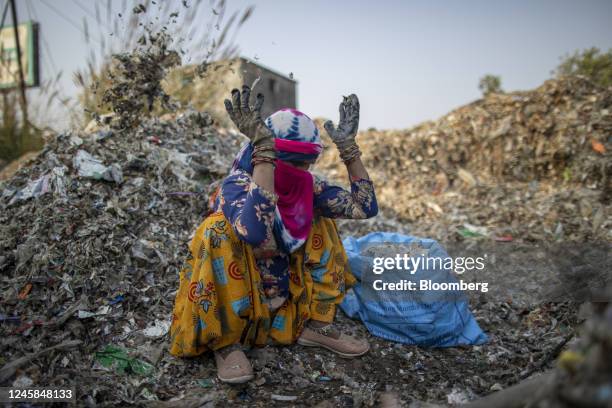 Worker sorts through a pile of waste from a paper mill at a plastic scrap yard in Muzaffarnagar District, Uttar Pradesh, India, on Thursday, Nov. 17,...