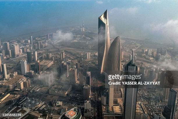 This aerial view shows mist covering the skyscraper skyline in the centre of Kuwait City on December 28, 2022.