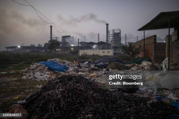 Paper mills spew smoke beyond a plastic scrap yard in Muzaffarnagar District, Uttar Pradesh, India, on Friday, Nov. 18, 2022. Plastic wrappers and...