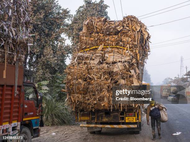 Trucks carrying raw materials are parked outside a paper mill in Muzaffarnagar District, Uttar Pradesh, India, on Friday, Nov. 18, 2022. Plastic...